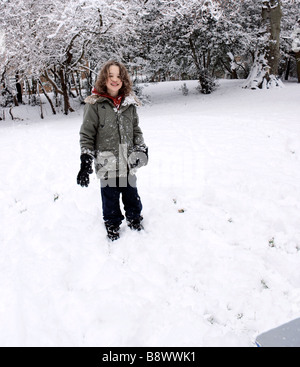 Glückliche sieben - Jahr - alten Jungen auf verschneiten Hügel auf eine seltene, sehr verschneiten Februartag in Islington, London UK Stockfoto