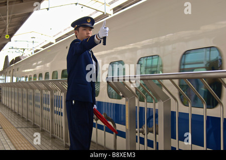 Plattform-Guard am Bahnhof Kyoto signalisieren dem Weggang von japanischen Hochgeschwindigkeitszug Shinkansen Stockfoto