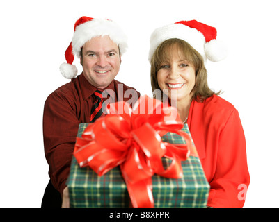 Ein nettes Paar mit einem Weihnachtsgeschenk für Sie isoliert auf weißem Fokus auf die Frau Stockfoto