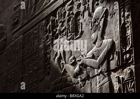 Wandrelief zeigt ägyptische Figur und hieroglyphischen Schnitzereien beleuchtet durch Sonnenlicht, "close up" Detail, Luxor-Tempel, Ägypten Stockfoto