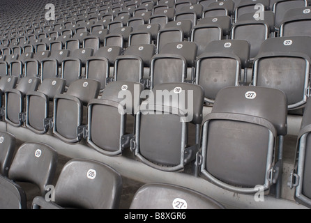 Zeilen der nummerierten Plastikstühle in einem Sportstadion Stockfoto