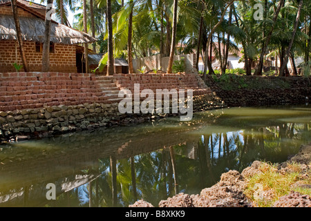 Haus am Ufer des tropischen Fluss umgeben mit Palmenwald. Stockfoto