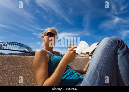 Eine Frau genießt einen Drink in der Opera Bar am Hafen von Sydney.  Sydney, New South Wales, Australien Stockfoto