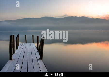 Eine frostige Mole auf Derwentwater wie die Sonne steigt über den Fjälls. Stockfoto