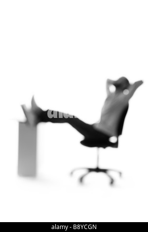 Silhouette eines Mannes durch einen Schreibtisch zu sitzen. Stockfoto