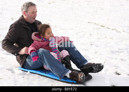 Snowboard Tochter weißen Vater Tochter Toddlerl schwarzen ethnischen Mischlinge glücklich lächelnde Spaß Schnee Eis junge Stockfoto