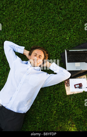 Ein Mann mit einem Laptop in einem Park Schweden. Stockfoto