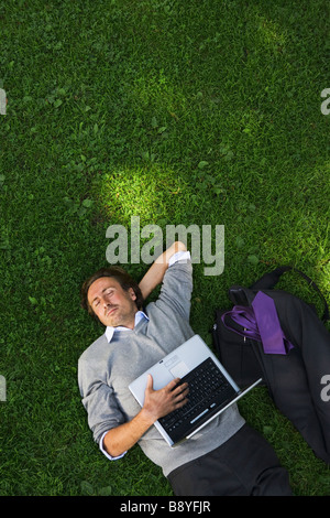 Ein Mann mit einem Laptop in einem Park Schweden. Stockfoto