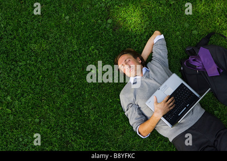 Ein Mann mit einem Laptop in einem Park Schweden. Stockfoto