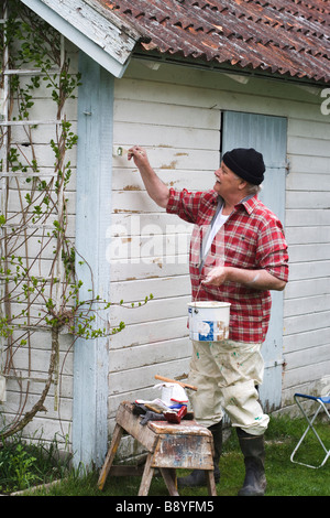 Älterer Mann seinem Sommerhaus Schweden Malerei. Stockfoto