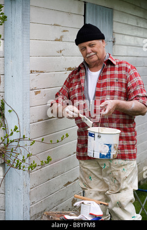 Älterer Mann seinem Sommerhaus Schweden Malerei. Stockfoto