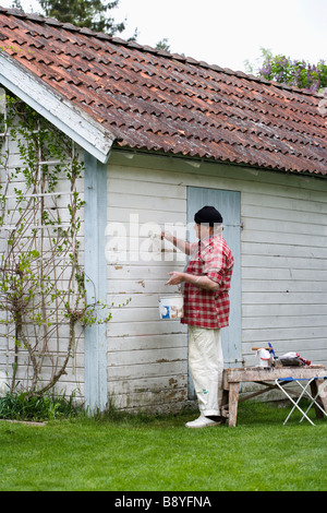 Älterer Mann seinem Sommerhaus Schweden Malerei. Stockfoto