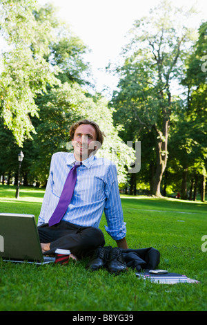 Ein Mann mit einem Laptop in einem Park Schweden. Stockfoto