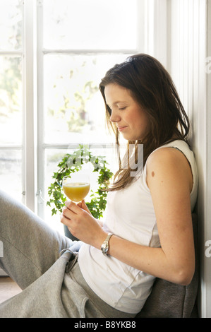 Eine junge Frau sitzt in einem Fenster Schweden. Stockfoto