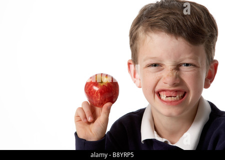 Junge Kind mit Apfel und keine Vorderzähne. weißen Hintergrund. Stockfoto