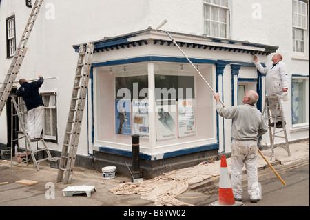 Drei Maler malen das äußere eines Ladens in Presteigne Dorf Powys an der walisischen Englisch Grenze Wales UK Stockfoto