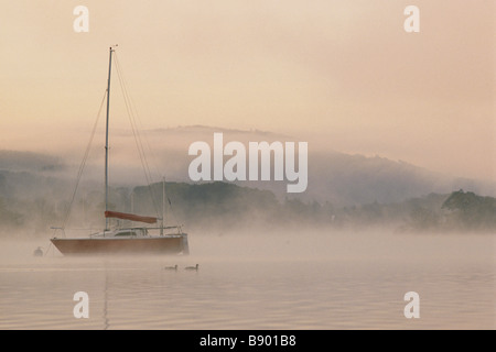 Neblige Sicht des Bootes am Lake Windermere im Morgengrauen von Cockshott Punkt Cumbria Stockfoto