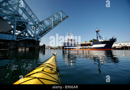 Ein Kajakfahrer Meer Paddel unter der Johnson Street Bridge in Victorias Innenhafen auf Vancouver Island, British Columbia, Kanada. Stockfoto