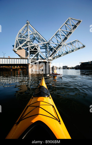 Meer Kajakfahrer paddeln unter der Johnson Street Bridge im Inner Harbour von Victoria auf Vancouver Island, British Columbia, Kanada. Stockfoto