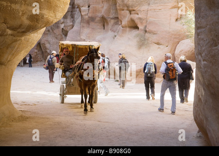 Touristen und ein Pferd und Wagen in den Siq, der Eingang nach Petra, Jordanien Stockfoto