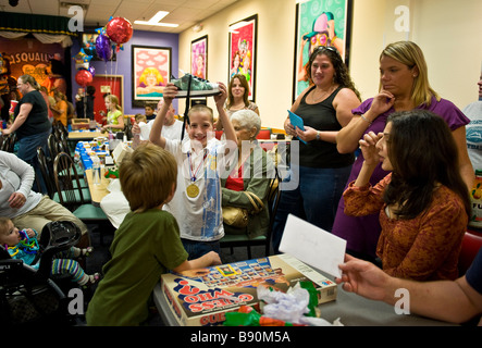 Junge öffnet präsentiert auf einer Geburtstagsparty Stockfoto