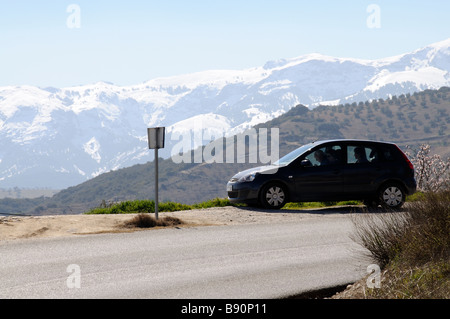 Touristen sitzen in ihren Mietwagen Blick auf Karte mit Schnee bedeckt Gebirgshintergrund in der Sierra Tejeda Südspanien Stockfoto