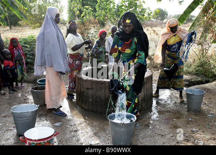 Nigeria: Frau zeichnen frisches Wasser aus einem Brunnen Stockfoto