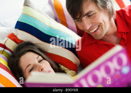 Ein junges Paar im Bett lesen. Stockfoto