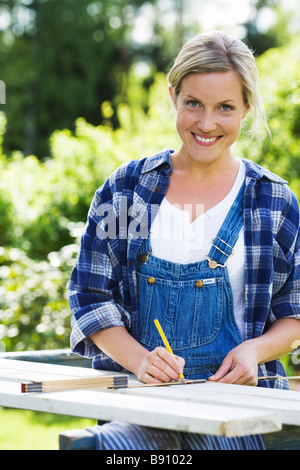 Eine Frau, Zimmerei in einem Garten Schweden zu tun. Stockfoto