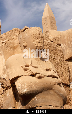 Verunstaltete Osiris-Statue, die ein Ankh in jeder Hand, Obelisken des Pharaos Tuthmosis ich hinter, Tempel von Karnak, Luxor, Ägypten Stockfoto