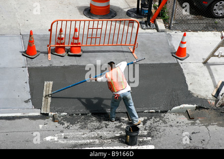 Mann einen frisch gezapftes nassen Beton Gehweg Glättung. Stockfoto