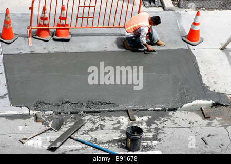 Mann einen frisch gezapftes nassen Beton Gehweg Glättung. Stockfoto