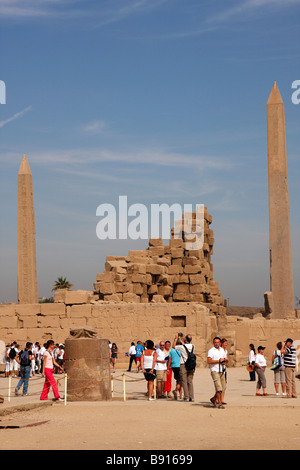 Ruinen von Karnak Tempel, Luxor, Ägypten. Touristen, Skarabäus-Käfer-Statue und Obelisken des Pharaos Tuthmosis I und Königin Hatshepsut Stockfoto