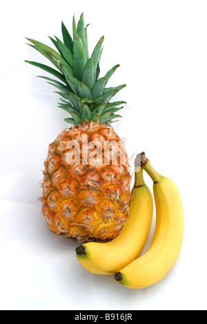 Eine schöne goldene Ananas und zwei perfekte gelbe Bananen, isoliert auf weiss Stockfoto