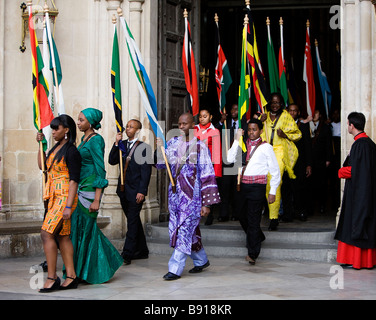 Junge Menschen mit den Fahnen des Commonwealth verlassen Westminster Abbey in London nach dem Commonwealth Tag Einhaltung Ser Stockfoto