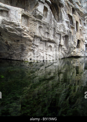 Buddhistische Schnitzereien spiegelt sich in grünes Wasser mit Teich-Unkraut Stockfoto