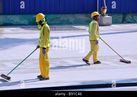 Dubai Mall Entwicklung Hard hat hoch vis Bauindustrie langweilig manuelle Arbeit Baustellenarbeiter fegen bis Besen Vereinigte Arabische Emirate VAE Stockfoto