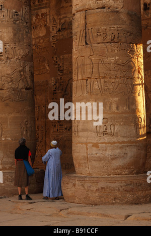 [Medinet Habu] Steinsäulen und Fremdenführer zeigt Hieroglyphen, Leichenhalle Tempel von Ramses III, "Westbank", Luxor, Ägypten Stockfoto