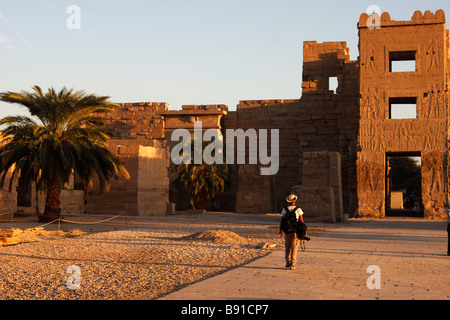 Touristen, die Ruinen der Totentempel [Medinet Habu], [syrische Tor] bei Einbruch der Dunkelheit "West Bank", Luxor, Ägypten zu verlassen Stockfoto