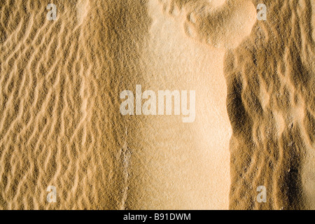 Nahaufnahme von Sand bedeckt Wüstenboden mit vom Wind verwehten Mustern und Texturen auf der Oberfläche Stockfoto