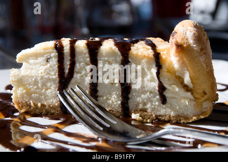 Stück Käsekuchen auf Teller mit Schokoladensirup Stockfoto