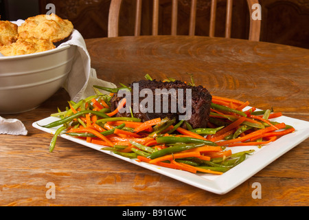 Rind, Rostbraten und Julienne grüne Bohnen und Karotten auf einem weißen Teller Stockfoto