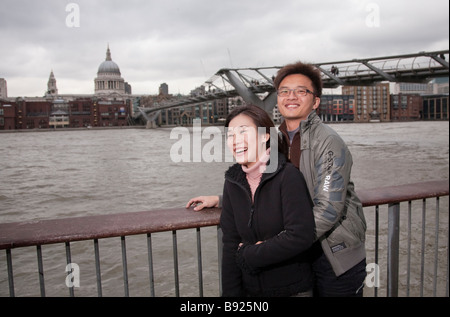 Asiatischen orientalischen Tourist paar in 20er / 30er Jahre in London, mit St Pauls Cathedral und Millennium Fußgängerbrücke Stockfoto