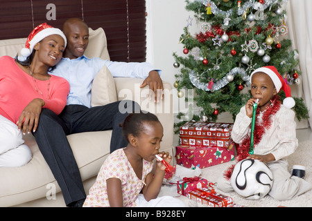 Mutter und Vater beobachtete ihre Kinder Schlag Krachmacher zu Weihnachten Stockfoto