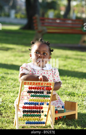 Tochter spielt mit ihren hölzernen Abakus auf dem Rasen Dewaal Park Cape Town Western Cape Provinz South Africa Stockfoto