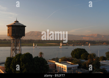 Ansicht der Feluke Boote Segeln am Nil in der Abenddämmerung mit Bergen und "West Bank" in Ferne, Luxor, Ägypten Stockfoto