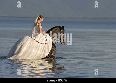 Braut auf reines Spanisch gezüchtete Pferd im Wasser Stockfoto