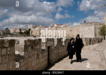 Eine Orthodoxe religiöse jüdische Paar wandern entlang der osmanischen Mauer um den westlichen Rand der Altstadt von Ostjerusalem Israel Stockfoto