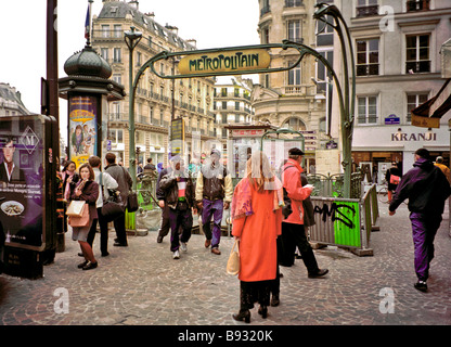 Parisern unterschiedlichen Alters und Rassen versammeln sich um das Zeichen für die u-Bahn-Haltestelle Cadet Stockfoto