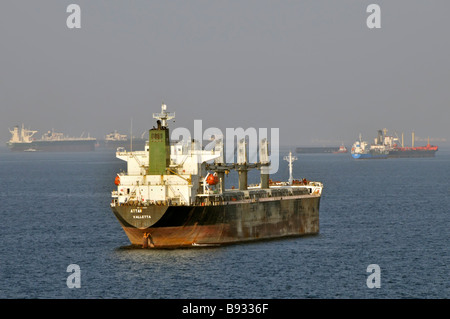 Unbeladene Schifffahrt in Hitzefeuer Massengutfrachter und Öltanker Küstengewässer ankern vor dem Bunkerhafen Fujairah der Vereinigten Arabischen Emirate Golf von Oman in der Nähe der Straße von Hormuz Stockfoto